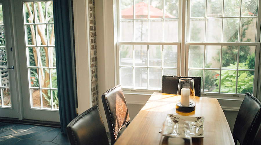 dining table and sun shining thorugh windows and doors taylorsville ut